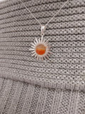 Sunset orange cabachon set in a sun shaped pendant.