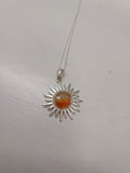 Sunset orange cabachon set in a sun shaped pendant.