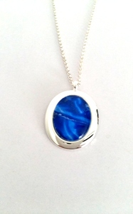 Oval pendant in abstract blue simple and stunning hand painted in bees wax and sealed in a glass cabochon 